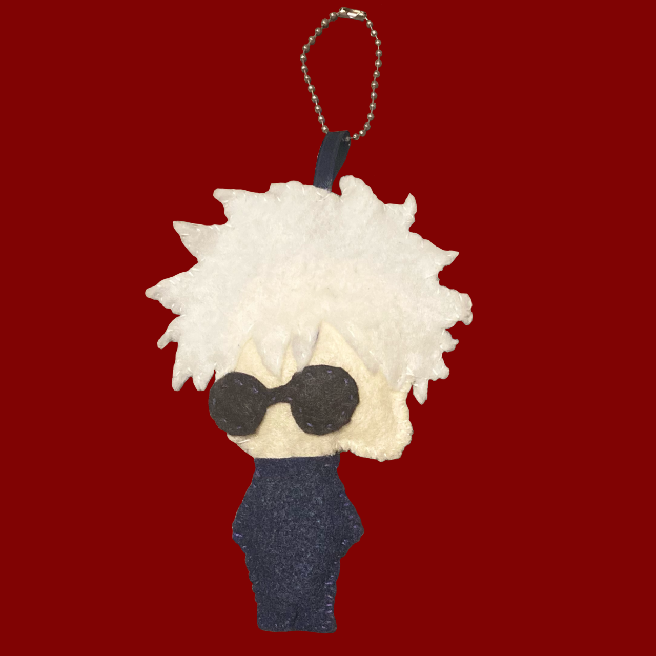 Front of a hand-sewn Satoru Gojo wearing glasses plush attached to a keychain