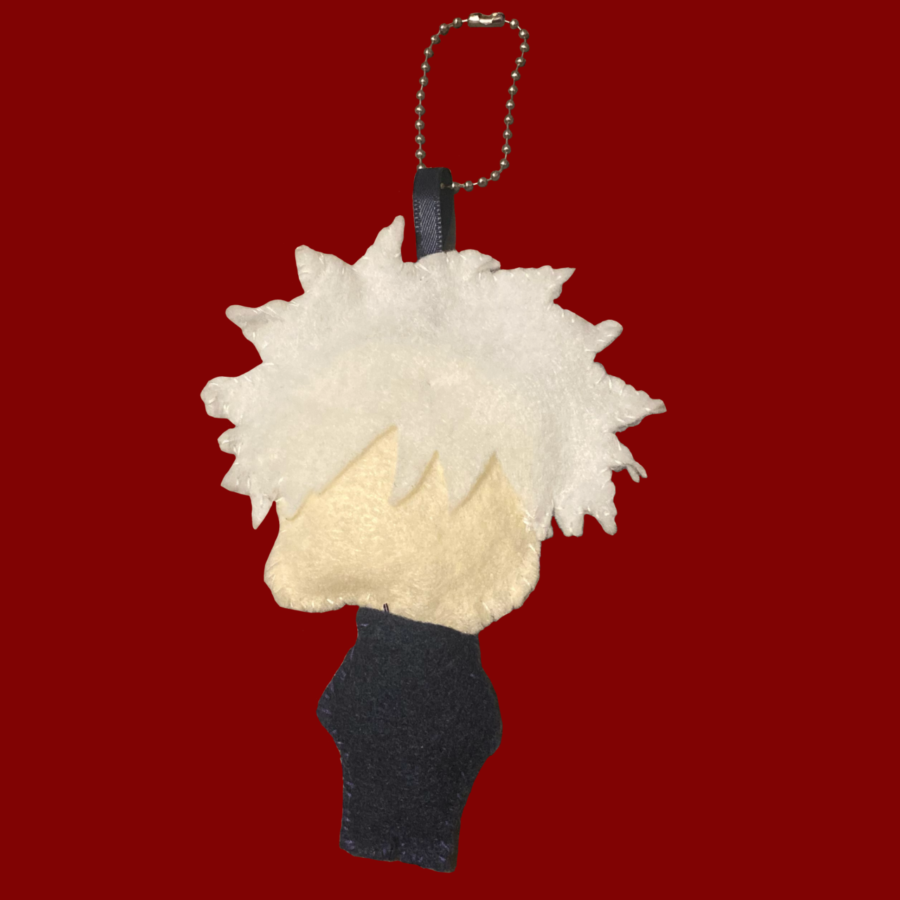 Back of a hand-sewn Satoru Gojo plush attached to a keychain